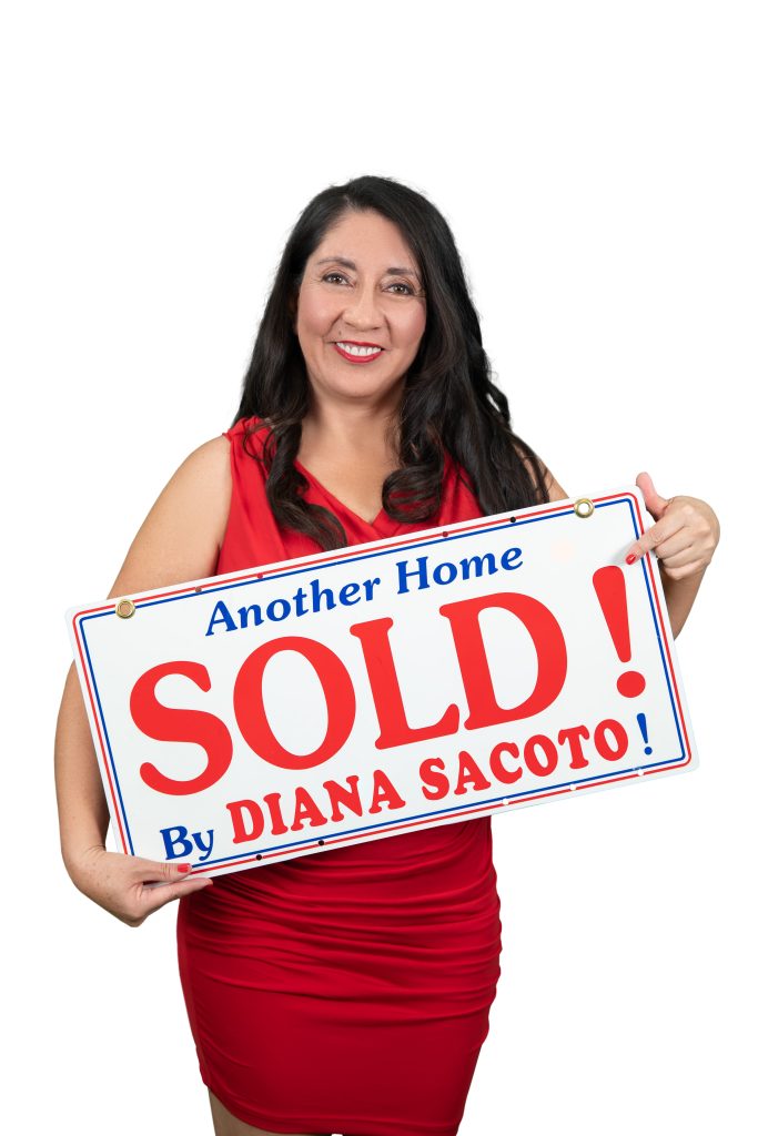 Diana Sacoto beside a sold real estate sign